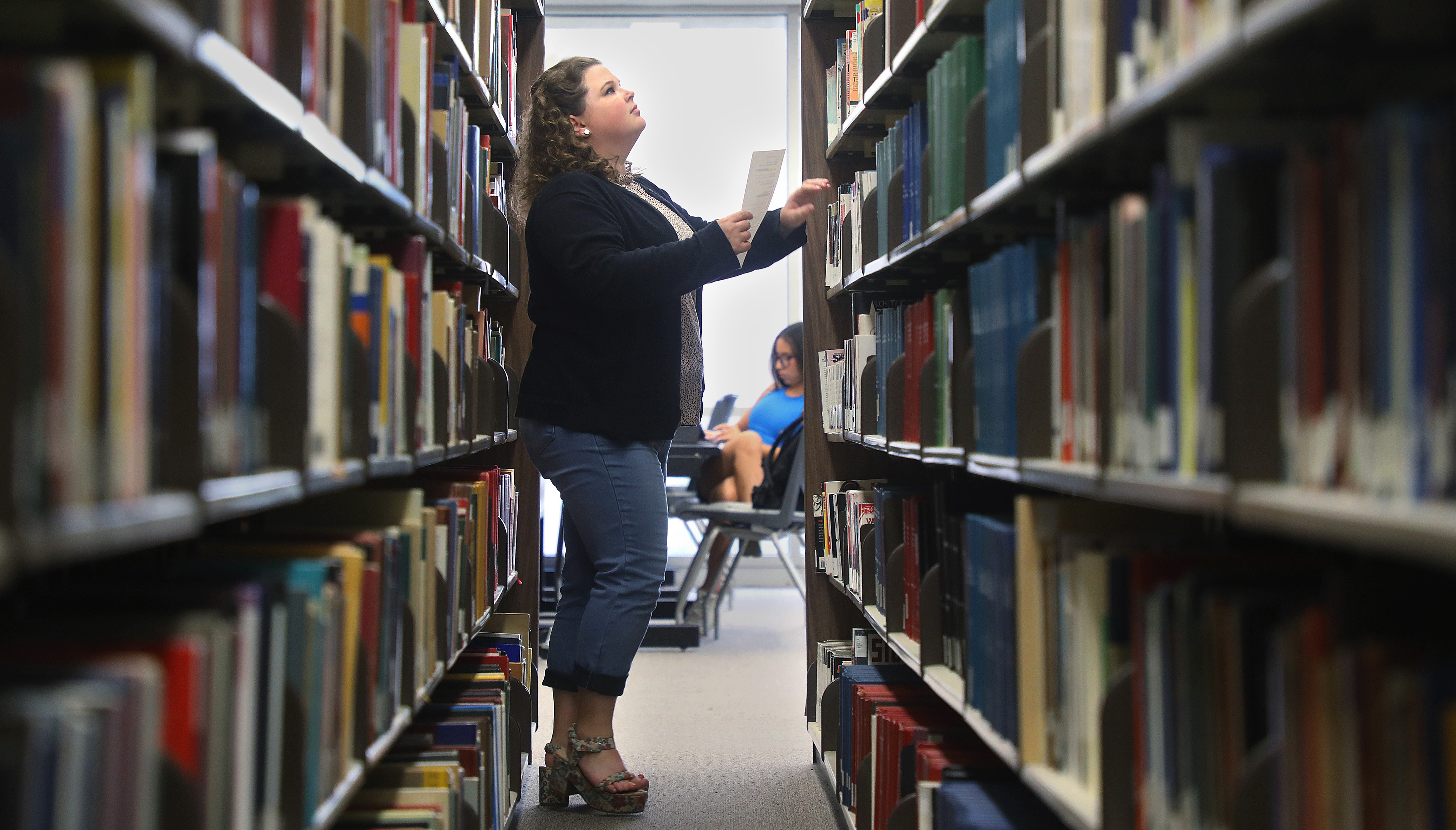 Bethany Startz searches for a book in the Evans stacks after a request from a “Get It For Me” patron.